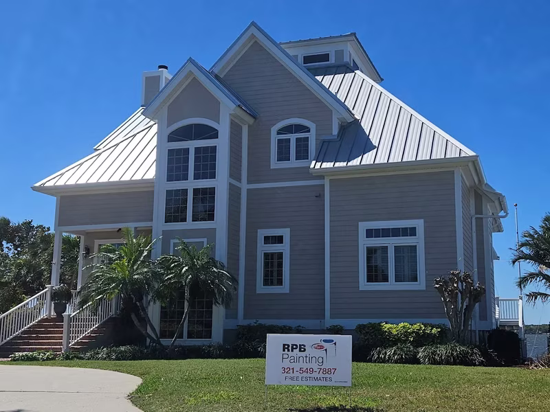 Gray coastal home exterior painting with metal roof by RPB Painting Florida